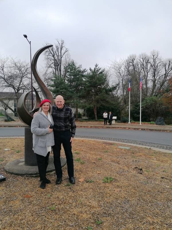 Betty and George in front of the flame of remembrance offered by an anonymous American
